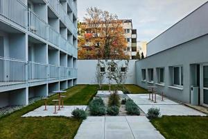 a courtyard of a building with tables and benches at Apartment Kysucká 1014 Top Floor & View in Košice