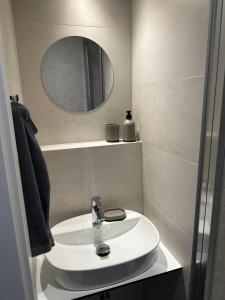 a bathroom with a white sink and a mirror at Apartment Kysucká 1014 Top Floor & View in Košice
