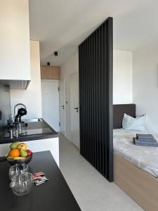a kitchen with a bed and a bowl of fruit on a table at Apartment Kysucká 1014 Top Floor & View in Košice