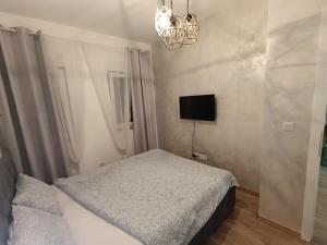 a bedroom with a bed and a tv on the wall at Apartman SATO in Brčko