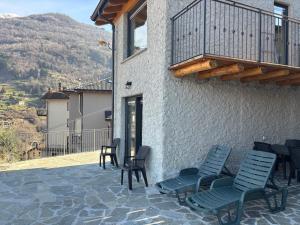a patio with chairs and a balcony with a view at Spigolo Nord in Bellano