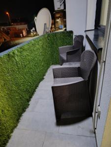 a row of chairs on a patio with grass at Apartman SATO in Brčko