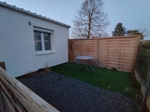 a small backyard with a table and a fence at Le Cocon in Cepoy +2 photos