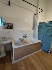 a bathroom with a large tub and a sink at Le Cocon in Cepoy