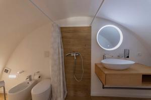 a bathroom with a sink and a toilet and a mirror at Suites7 in San Donato di Lecce +36 photos