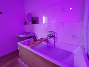 a pink bathroom with a tub and a sink at Le Cocon in Cepoy