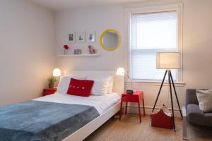a bedroom with a bed with a red pillow and a chair at Superior Queen Bed & Fulton Bed in Mount Vernon