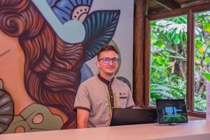 a man sitting at a table with a laptop at Lost Iguana Resort and Spa in Fortuna +81 photos