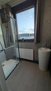 ein Badezimmer mit Dusche, Waschbecken und Fenster in der Unterkunft BUSINESS-MOTEL & XL-Parking, 24h-Checkin in Heimsheim