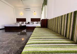 a hotel room with two beds and a striped carpet at Gagana Resort in Anuradhapura
