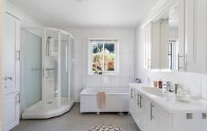 a white bathroom with a tub shower and a sink at Villa Nygård in Jelsa +27 photos