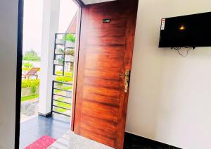 a wooden door with a television on a wall at Gagana Resort in Anuradhapura