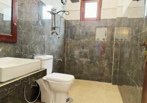 a bathroom with a toilet and a sink and a shower at Gagana Resort in Anuradhapura +51 photos