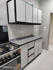 a kitchen with white cabinets and a stove at SunShine in Quseir