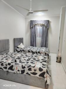 a bedroom with two beds with a cow blanket at SunShine in Quseir