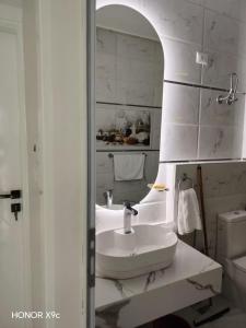 a white bathroom with a sink and a mirror at SunShine in Quseir +28 photos
