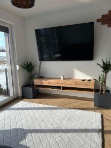a living room with a large flat screen tv on a wall at Apartament Bond in Szczawno-Zdrój