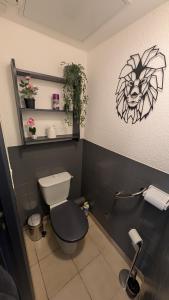 ein Badezimmer mit Toilette und einem Löwen an der Wand in der Unterkunft Le Maréchal in Dole + 16 Fotos