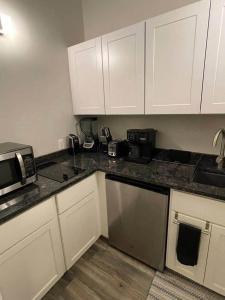 a kitchen with white cabinets and black counter tops at Lehi East Bench Private Apt! in Lehi +8 photos