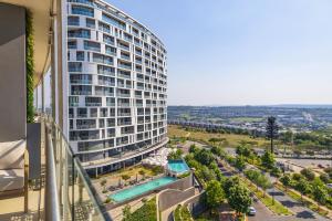 an apartment building with a pool in front of a street at Heatherstone Haven in Midrand