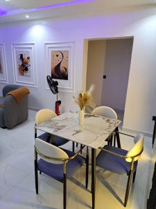a dining room with a table and chairs at Diolux Comfy Apartments in Sangotedo