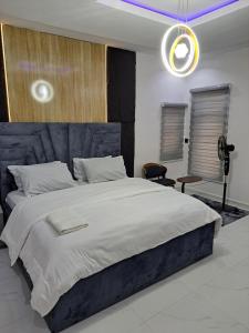 a bedroom with a large bed with a blue headboard at Diolux Comfy Apartments in Sangotedo