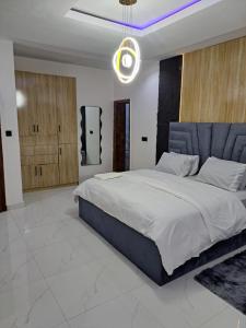 a bedroom with a large bed with a blue headboard at Diolux Comfy Apartments in Sangotedo