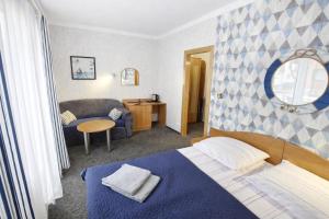 a hotel room with a bed and a couch at Villa Atol in Niechorze