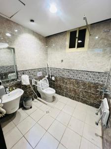 a bathroom with a toilet and a sink and a tub at أبراج المصايف للشقق المخدومة in Taif