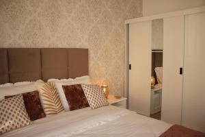 a bedroom with a white bed and a mirror at Vila Prata Dourada 1 in Ferreira do Zêzere