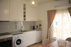 a kitchen with a sink and a washing machine at Vila Prata Dourada 1 in Ferreira do Zêzere