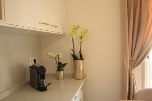a kitchen counter with two vases with flowers in it at Vila Prata Dourada 1 in Ferreira do Zêzere
