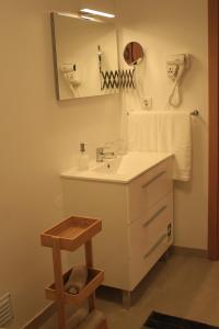 a bathroom with a sink and a mirror at Vila Prata Dourada 1 in Ferreira do Zêzere