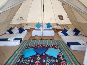 a tent with two beds and blue pillows in it at Puerto Silanguin Beach Resort in Subic