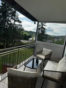 a balcony with two chairs and a coffee table at Mia's Landzeit in Nettersheim