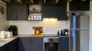 a kitchen with a stainless steel refrigerator and cabinets at Highlander in Dinner Plain +5 photos