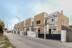 a row of houses on the side of a road at Beachside Villa with Private Garden in Aldeia do Meco