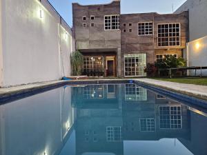 a swimming pool in front of a building at Las fincas Jiutepec in Jiutepec