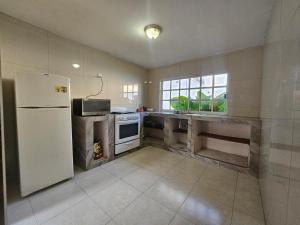 a kitchen with a white refrigerator and a sink at Las fincas Jiutepec in Jiutepec