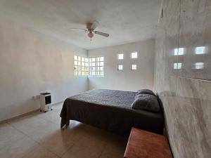 a bedroom with a bed and a ceiling fan at Las fincas Jiutepec in Jiutepec +9 photos