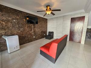 a living room with a couch and a ceiling fan at Las fincas Jiutepec in Jiutepec