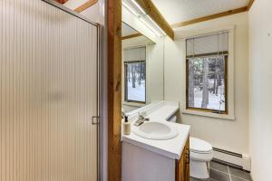 a bathroom with a sink and a toilet and two windows at Resort-Style Community! Quechee Chalet w/ Deck in Quechee +41 photos