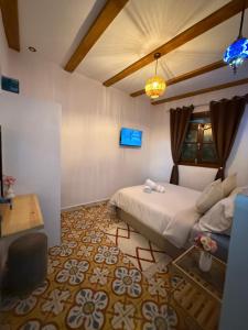 a bedroom with a bed and a tv on the wall at Dar Diamante Azul in Chefchaouen