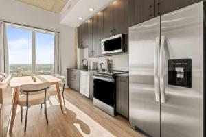 a kitchen with a table and a stainless steel refrigerator at Elegant 1BR Walkable to Dining, Pool + Gym in Tampa +17 photos