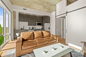 a living room with a couch and a table at Elegant 1BR Walkable to Dining, Pool + Gym in Tampa