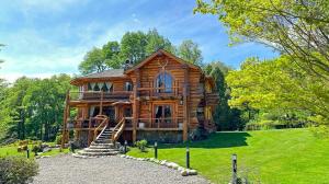 a large log cabin with stairs to the front yard at Rotui Luxury Village in San Martín de los Andes