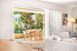 a living room with a table and a couch at Solara Escape Mooloolaba - Luxe Pet-Friendly Home in Alexandra Headland +47 photos