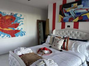a bedroom with a white bed and a painting at Casa Azul-Xpuha, Tulum, Mexico in Xpu Ha +5 photos