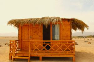 a wooden hut with a thatched roof in the desert at Dagal Camp - دجل كامب in Sharm El Sheikh