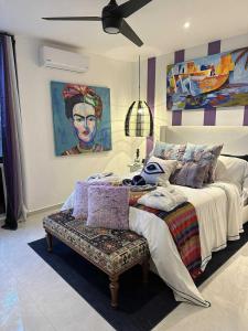 a bedroom with a bed and a painting on the wall at Casa Azul-Xpuha, Tulum, Mexico in Xpu Ha